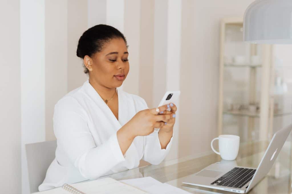 business owner in white suit using iphone